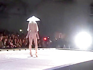 Seductive Fashion Model In A Weird Hat Walks Down The Catwalk In The Nude