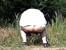 Mature Woman Shitting Outdoor On A Field