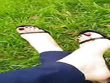 Sweet Feet With Red Toenails In Black Flip Flops