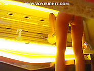 Woman Undressing In Tanning Room
