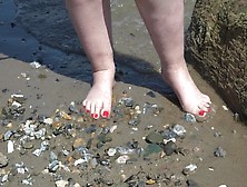 A Wide Woman With Humongous Feet Walks Along The Shore.