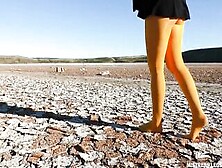Barefoot Walking By Dried Up Lake Inside Yellow Stockings
