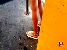Candid Legs And Feet With Red Painted Toenails Of A Young Brunette Woman At The Bus Stop