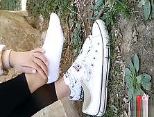 Chinese Girl Sprains Foot In White Ankle Socks And Black Leggings