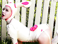 Girl In A Bunny Suit Strips In The Backyard By A White Fence