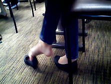 College Lady Playing With Her Ballerina Shoes Underneath The Chair At The Library