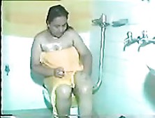 Une Femme Enrobée Se Lave Dans La Salle De Bains