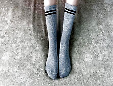 Girl In Bed Strokes Her Legs In Gray Cotton Socks