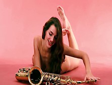 Ambitious Beautiful Model Chick Posing With A Saxophone In The Studio